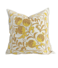 Decorative pillow with gold floral embroidery on a white background