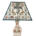 Decorative lamp with floral and rabbit design on the shade against a white background