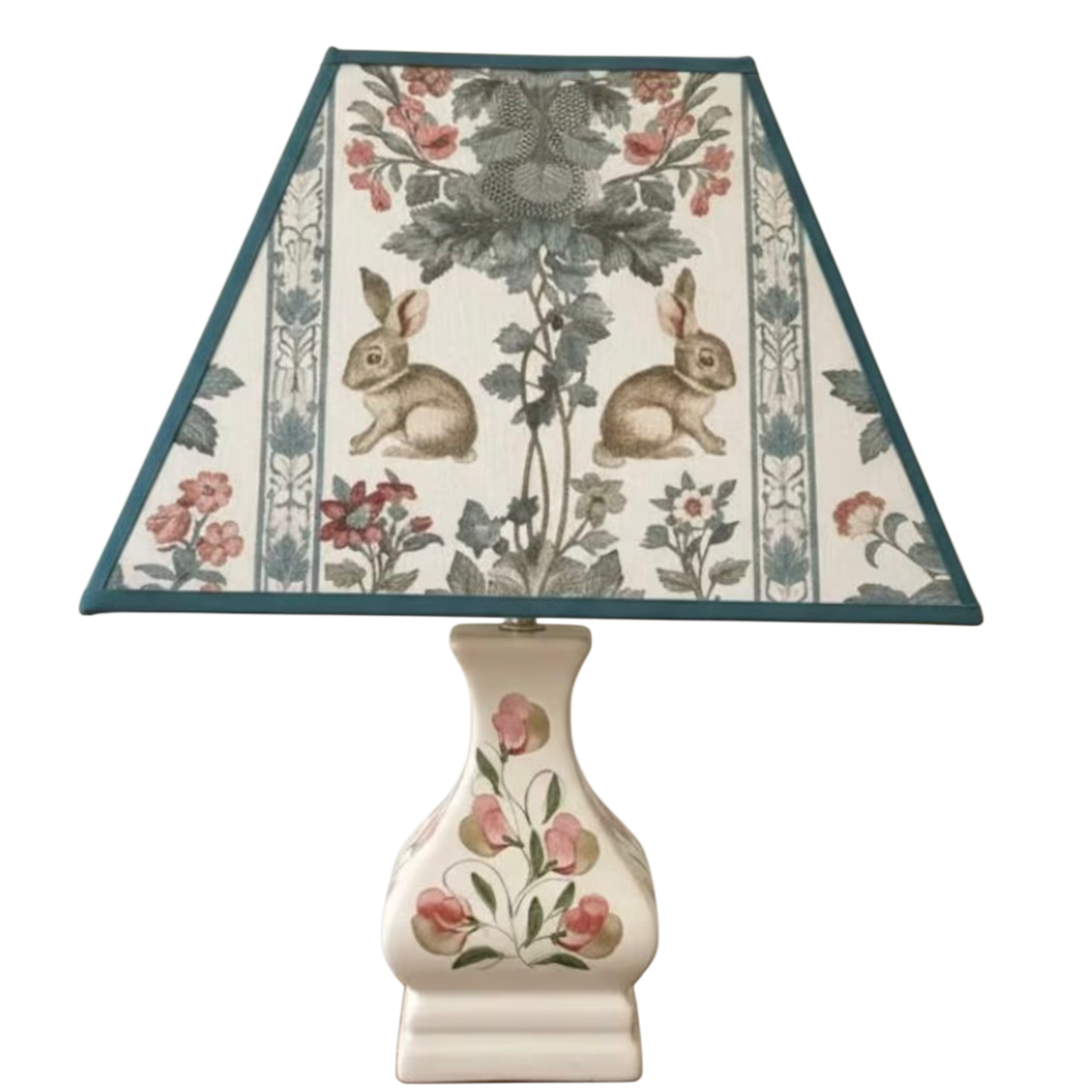 Decorative lamp with floral and rabbit design on the shade against a white background