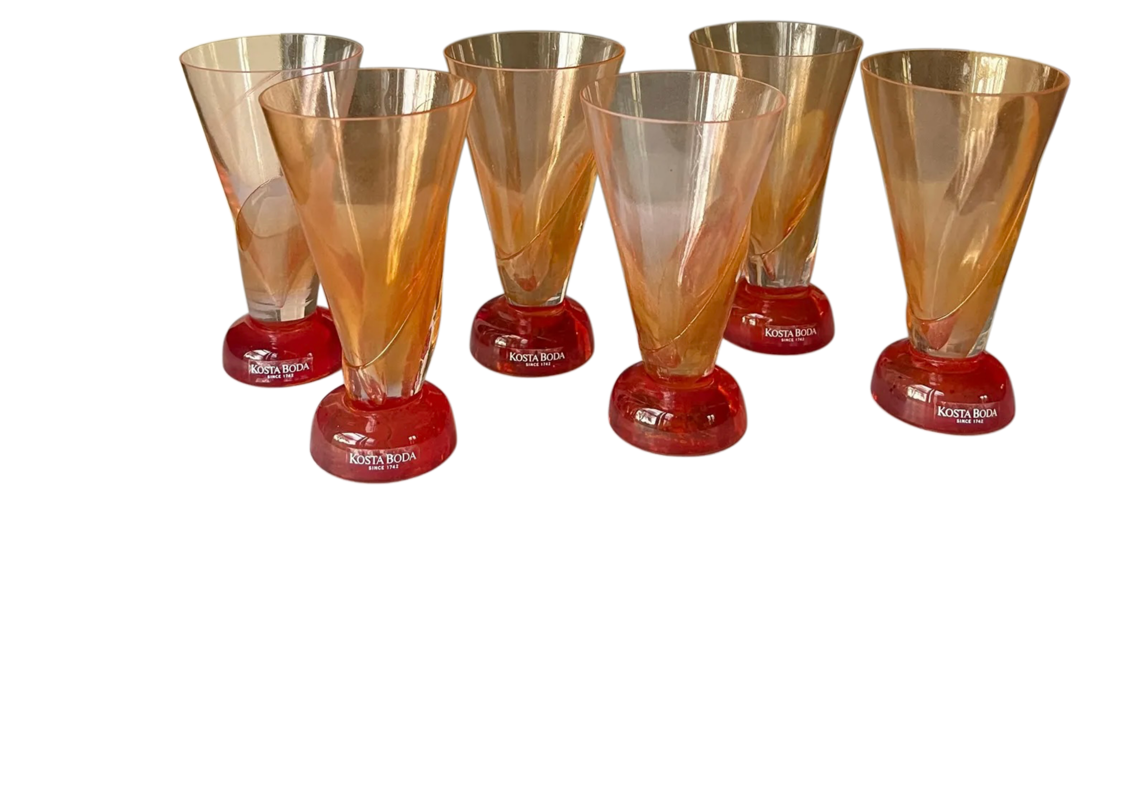 Set of six amber and red glass tumblers on a white background