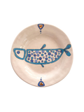 Ceramic plate with blue fish design on a beige background