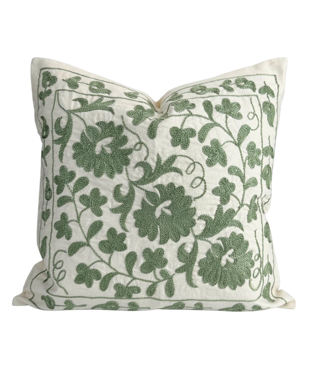 Decorative pillow with green floral pattern on a white background