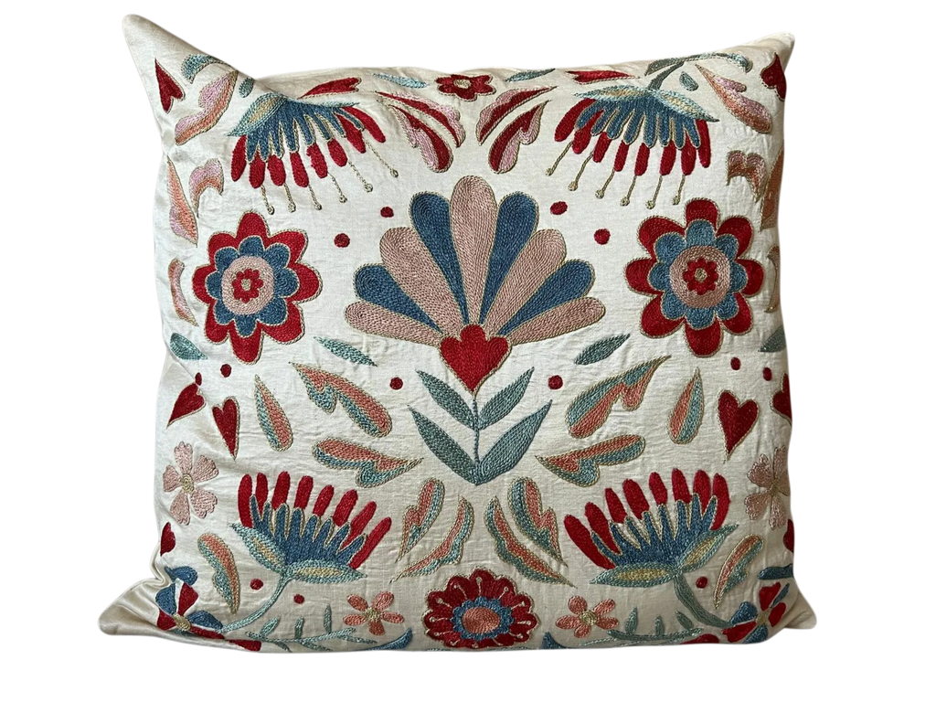 Decorative pillow with floral and leaf patterns on a white background