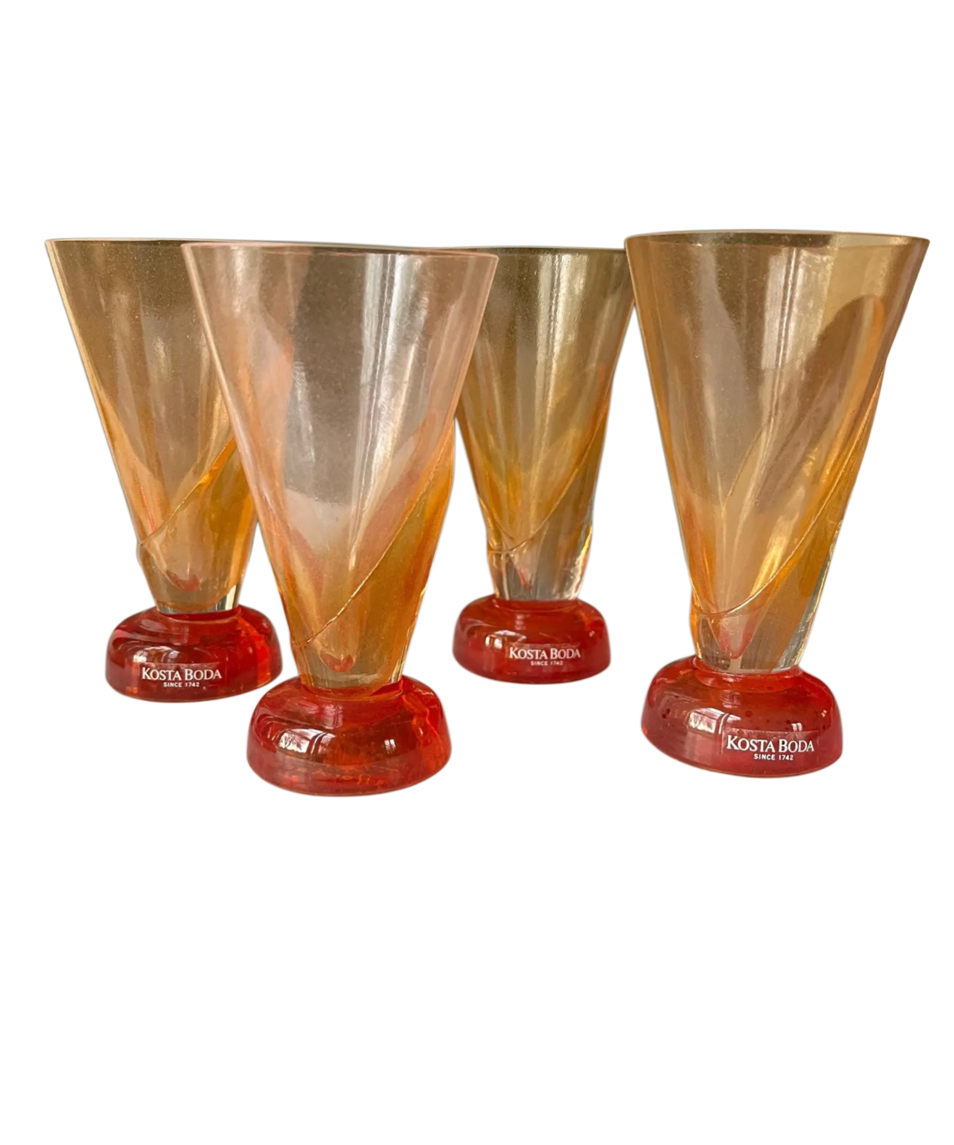 Three Kosta Boda glasses with orange and red design on a white background