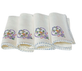 Set of four folded white napkins with embroidered designs on a white background