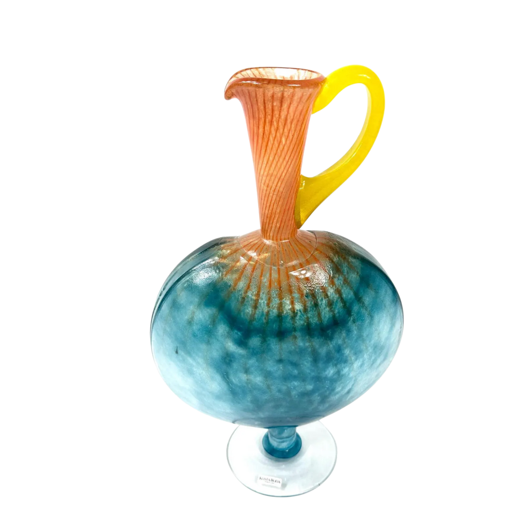 Colorful glass pitcher with a blue base and yellow handle on a white background