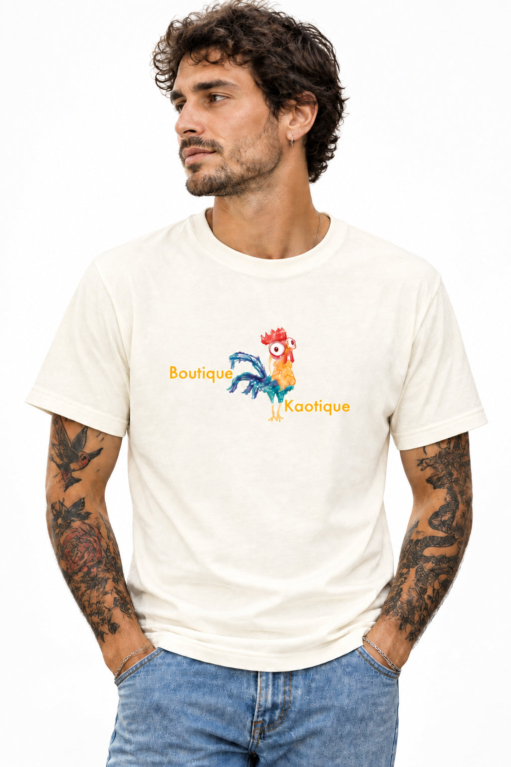 An off-white short-sleeve t-shirt with a colorful graphic of a cartoon rooster and the text 'Boutique Kaotique' printed on the chest, shown against a plain white background.