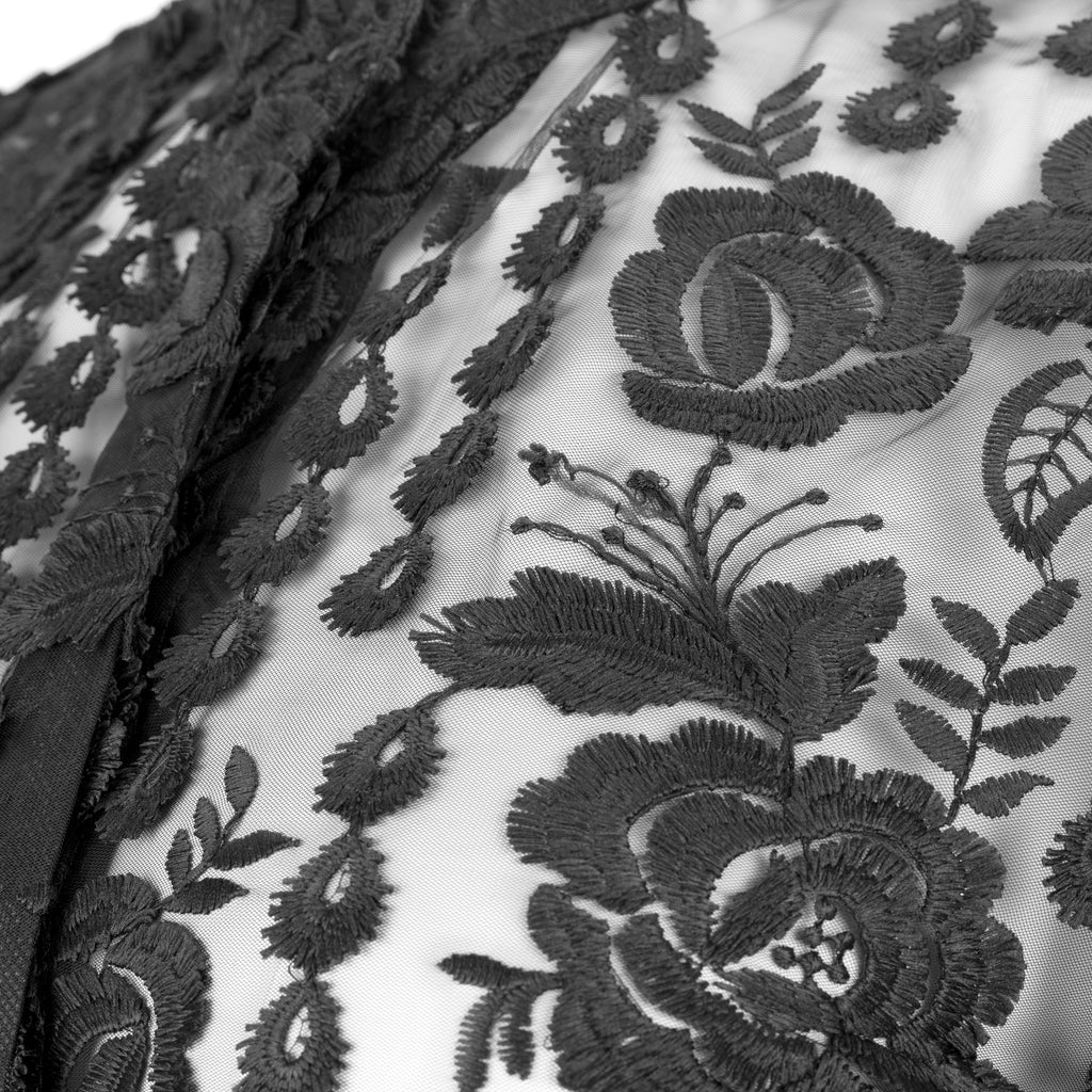 Close-up of black floral lace fabric on a white background. Black lace dress — handmade black lace designer dress from Hanout Boutique Marrakech, fitted, limited edition occasion piece