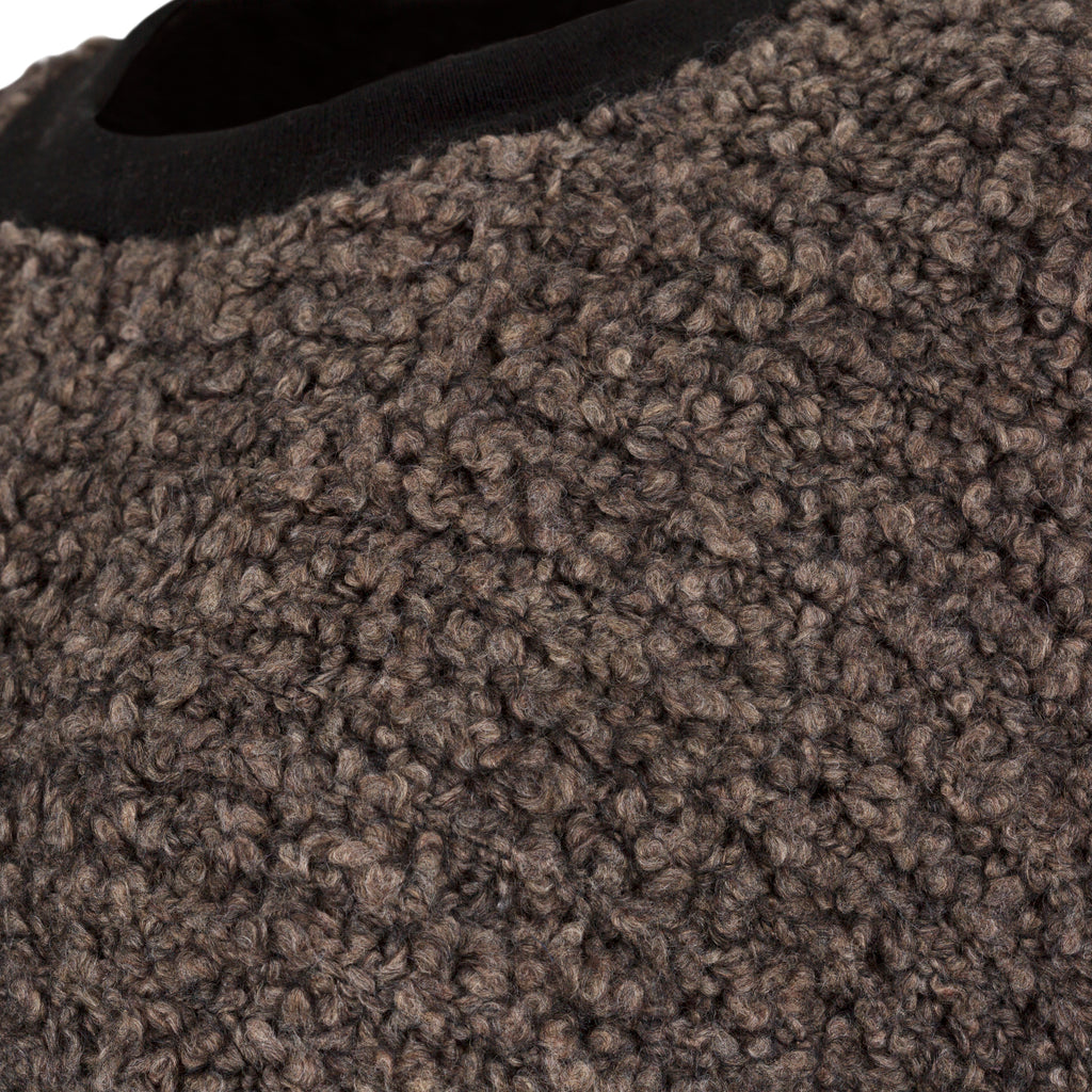 Close-up of brown textured carpet. Chocolate wool cashmere jumper — handmade brown wool blend designer jumper from Hanout Boutique Marrakech, relaxed fit, limited edition