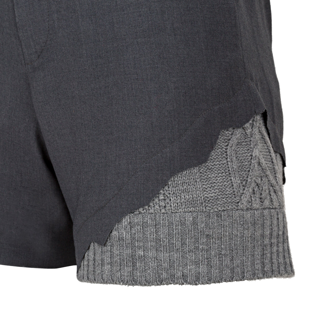 Close-up of a dark gray and light gray textured fabric edge on a white background. Wool blend shorts — handmade designer wool blend shorts from Patrick Owen Jakarta, tailored fit, limited edition piece