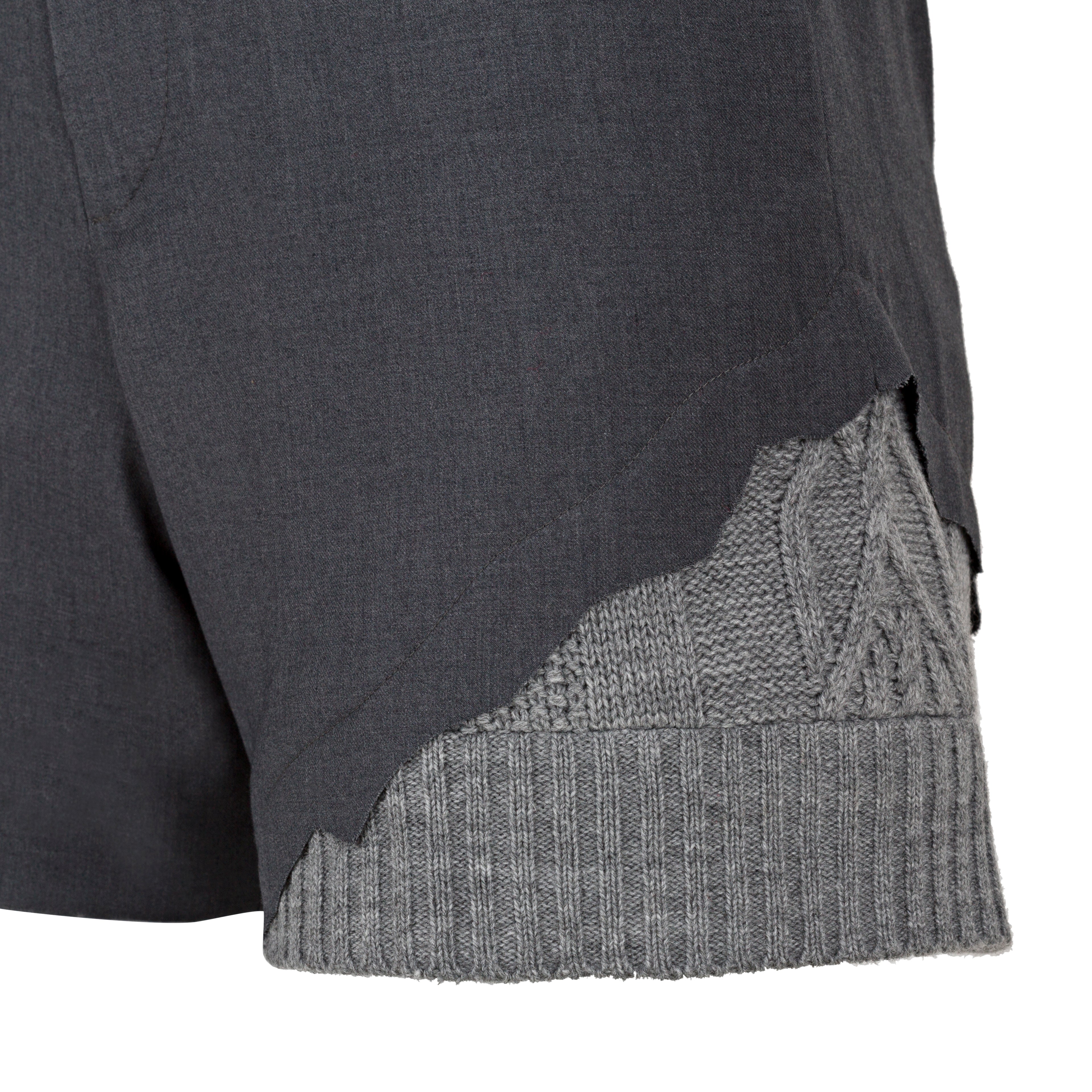 Close-up of a dark gray and light gray textured fabric edge on a white background. Wool blend shorts — handmade designer wool blend shorts from Patrick Owen Jakarta, tailored fit, limited edition piece