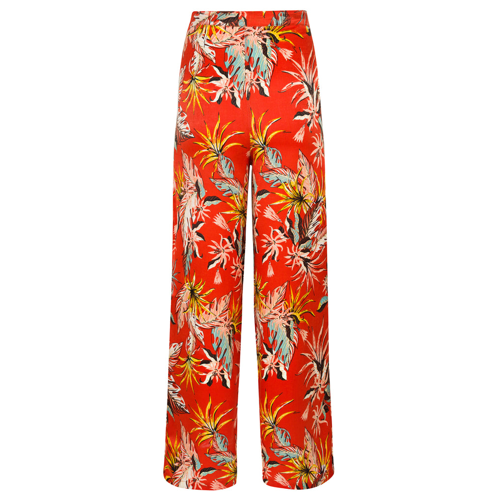 Red floral-patterned pants on a white background. Orange patterned silk pants — handmade orange silk designer pants with vibrant print from Hanout Boutique Marrakech, relaxed fit