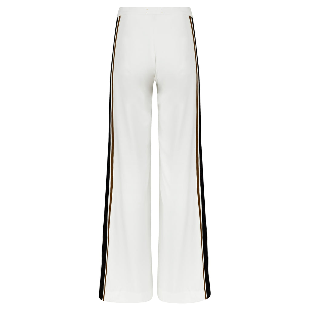 White pants with black side stripes on a white background. Striped trousers — handmade designer striped cotton trousers from Major Minor Jakarta, relaxed fit, limited edition summer