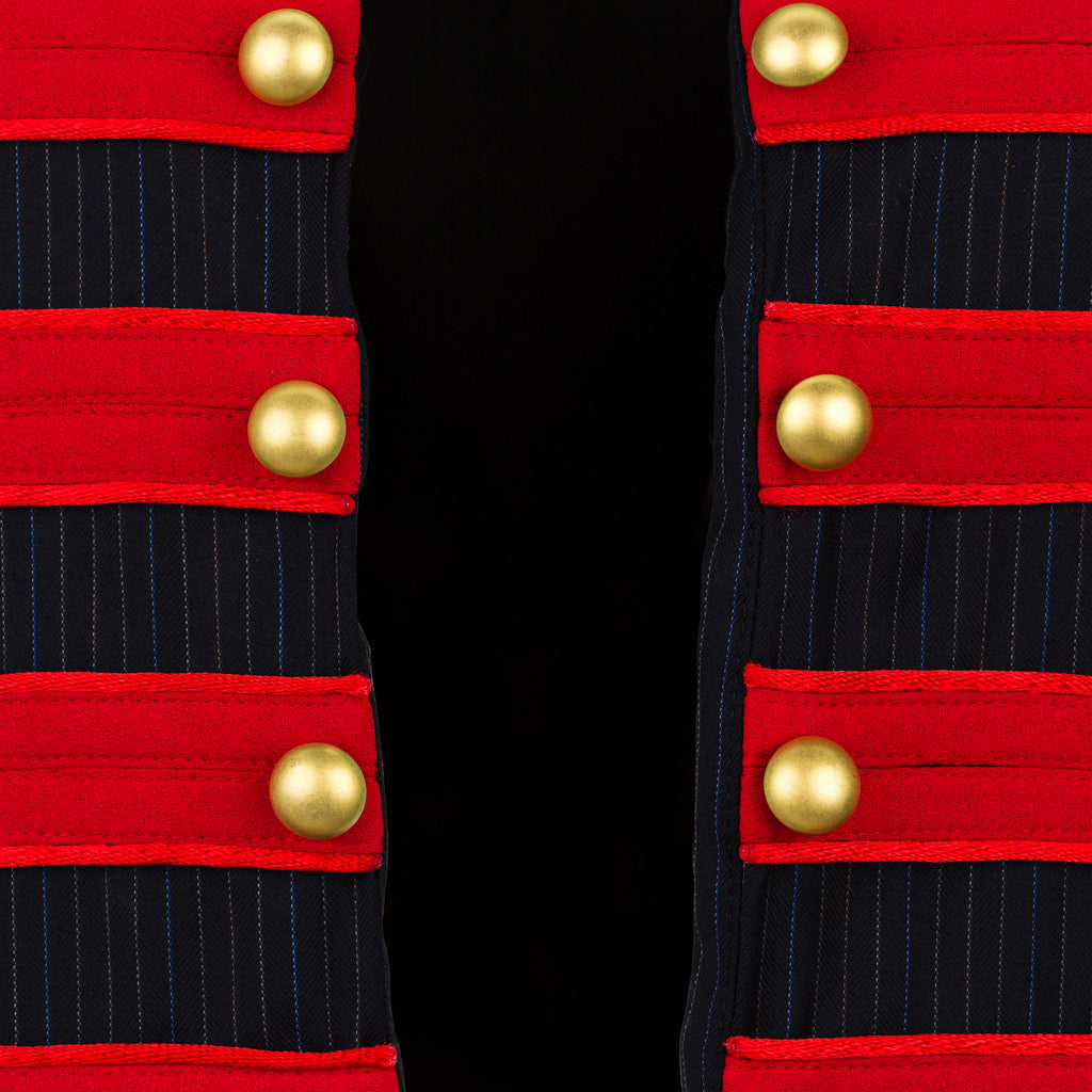Close-up of a military-style jacket with red and navy stripes and gold buttons on a black background. Soldier vest — handmade designer cotton vest from Major Minor Jakarta, relaxed fit, limited edition summer piece