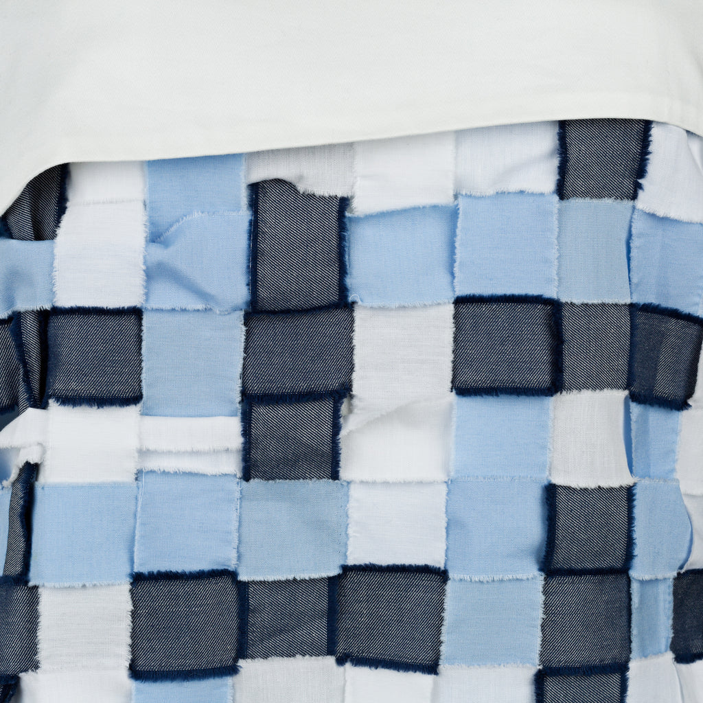 Close-up of a woven fabric with blue, gray, and white squares. Indonesian stringy top — handmade designer cotton top with string detail from Major Minor Jakarta, relaxed fit, limited edition