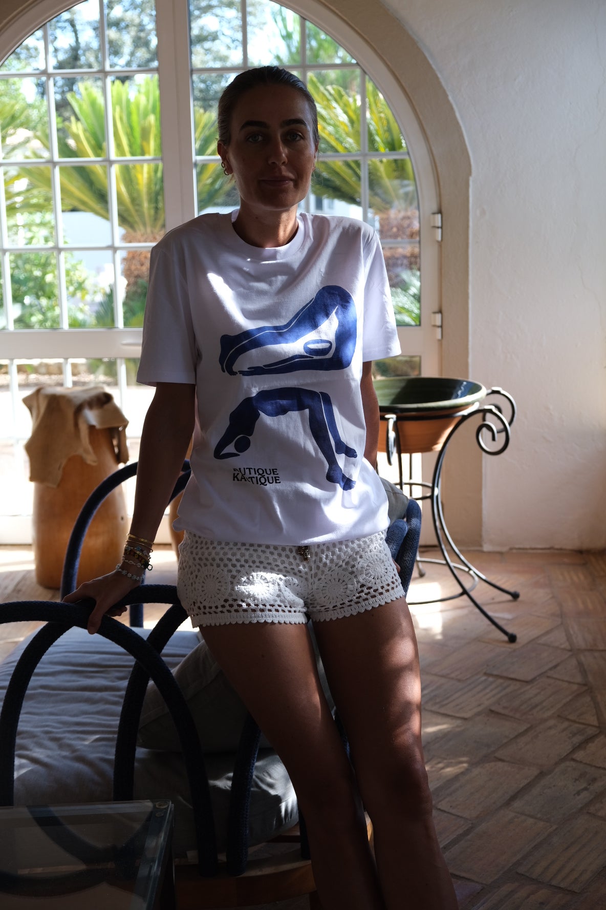 Person wearing a white t-shirt with a blue logo in an indoor setting