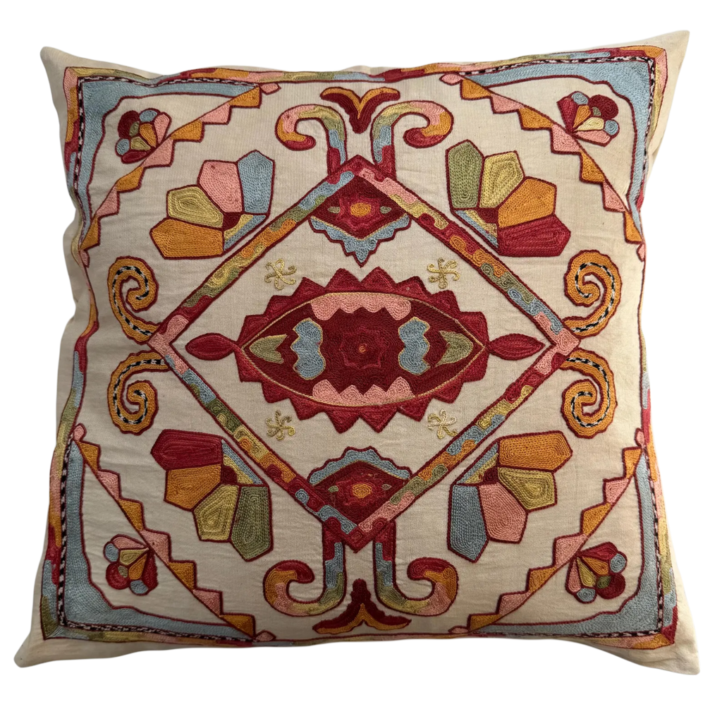 Decorative pillow with intricate geometric pattern on a beige background