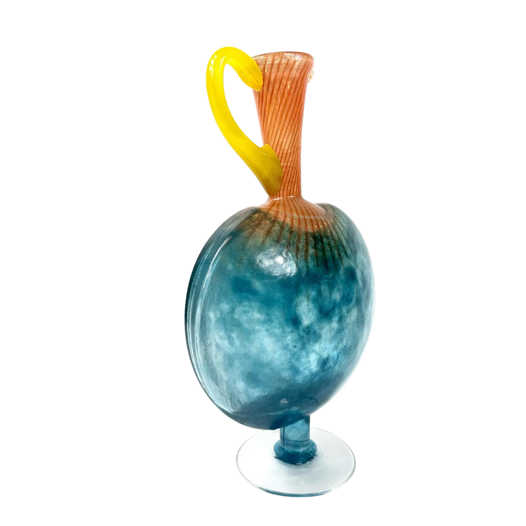 Glass sculpture with blue base, orange and yellow handle on a white background