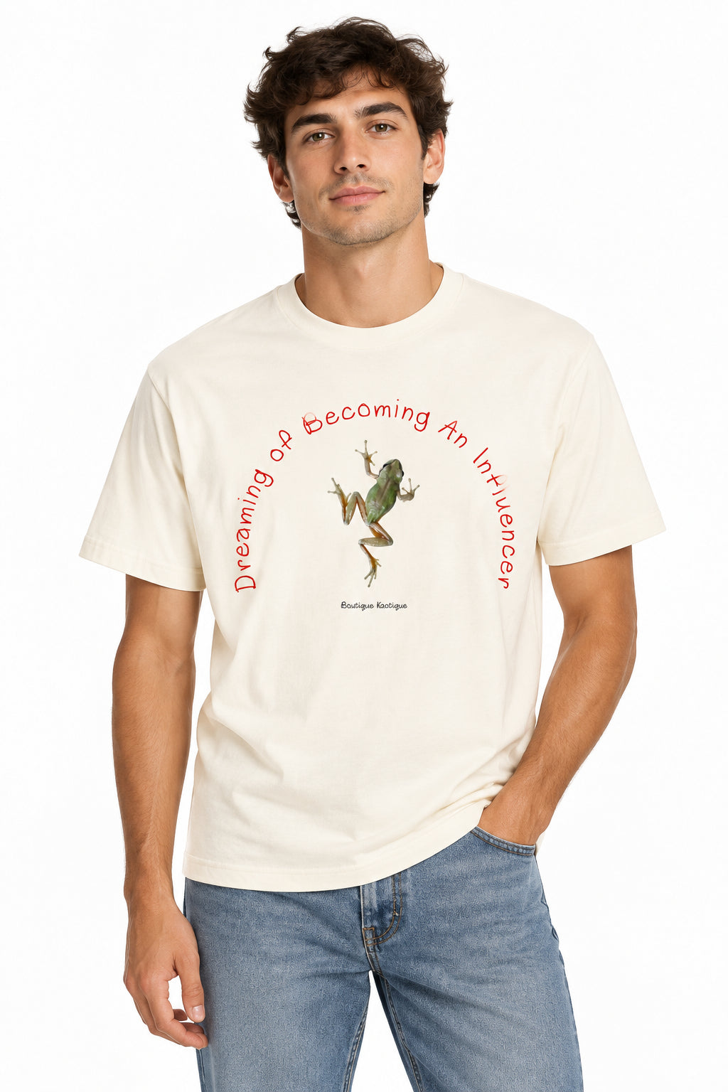 An off-white short-sleeve t-shirt with a graphic print featuring a green frog and red text that reads 'Dreaming of Becoming An Influencer' with 'Boutique Katiqee' printed below the frog.