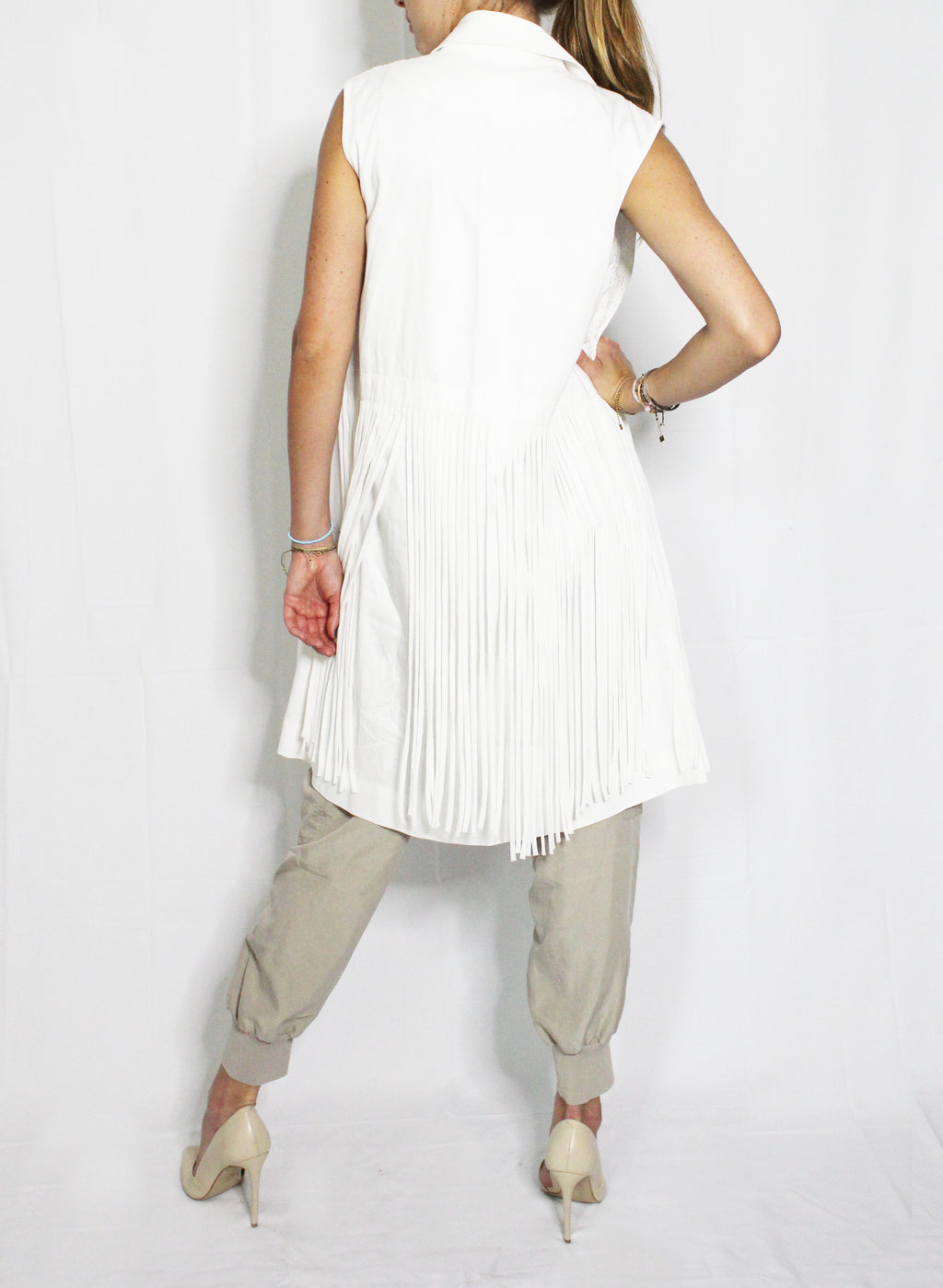 Person wearing a white pleated sleeveless top and beige pants on a white background, Indonesian stringy vest — handmade designer cotton vest with string detail from Major Minor Jakarta, relaxed fit, limited edition
