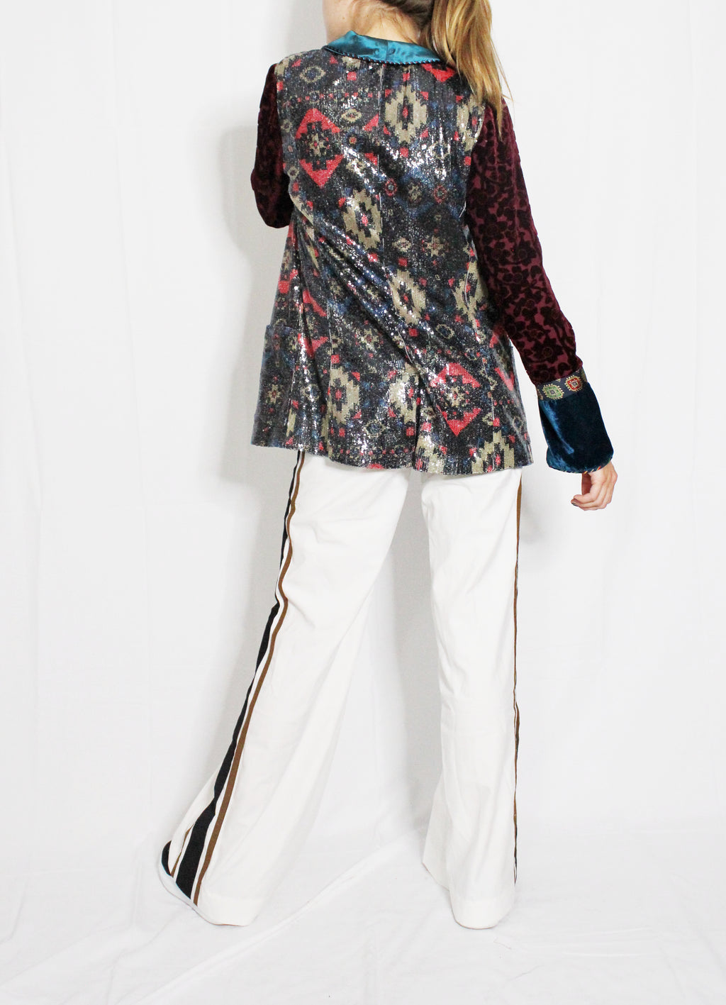 Person wearing a colorful patterned jacket and white pants on a white background. Striped trousers — handmade designer striped cotton trousers from Major Minor Jakarta, relaxed fit, limited edition summer