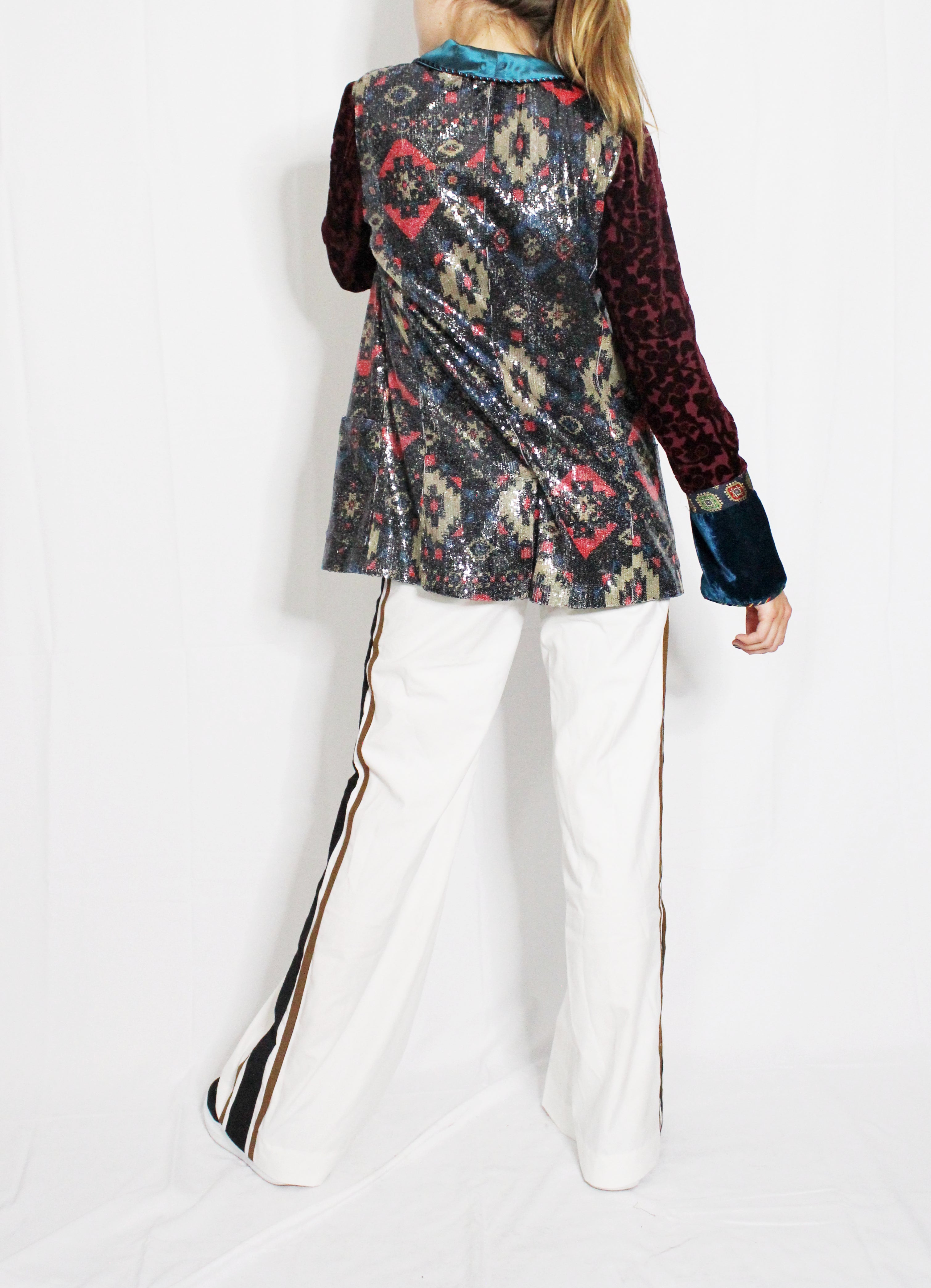 Person wearing a colorful patterned jacket and white pants on a white background. Striped trousers — handmade designer striped cotton trousers from Major Minor Jakarta, relaxed fit, limited edition summer