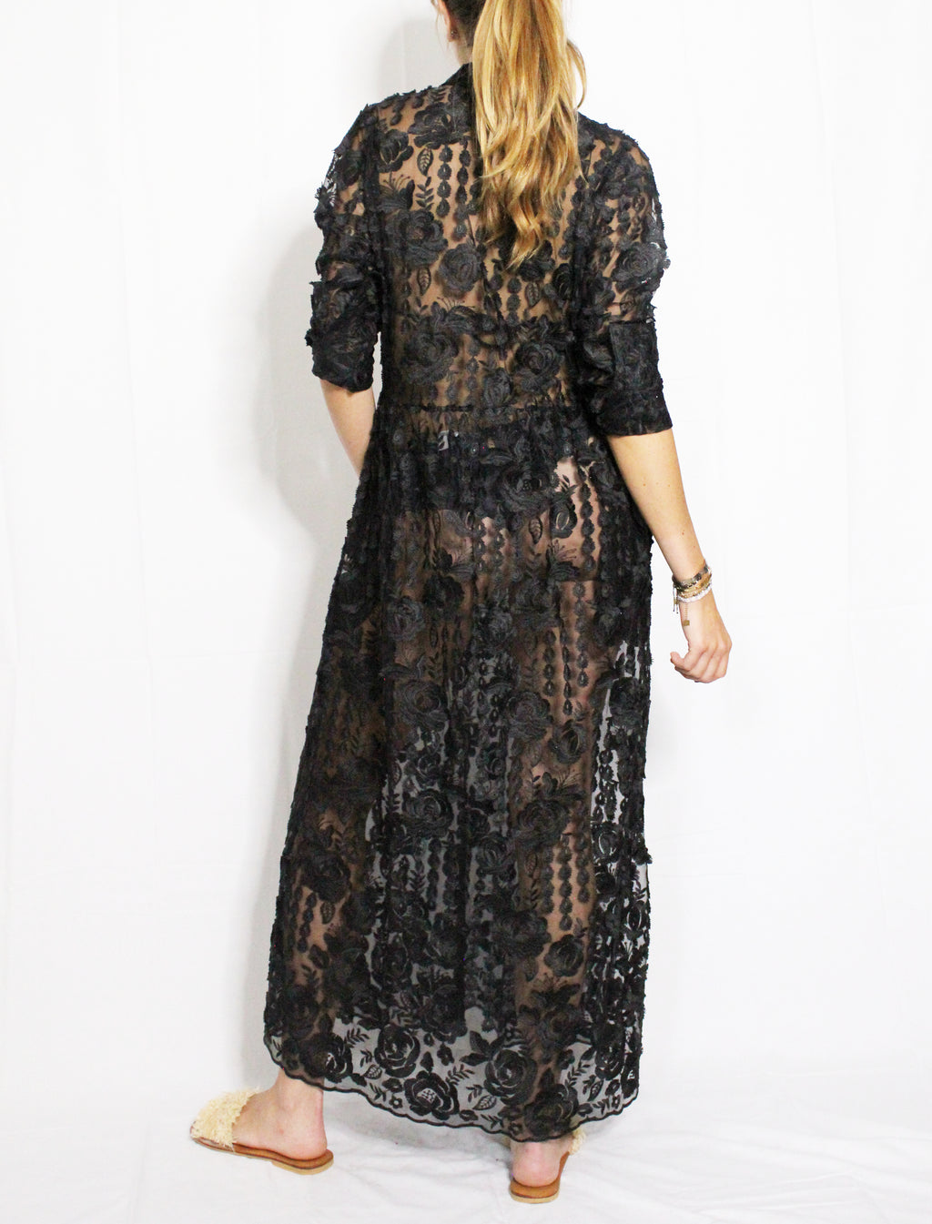 Black lace dress worn by a person on a white background. Black lace dress — handmade black lace designer dress from Hanout Boutique Marrakech, fitted, limited edition occasion piece
