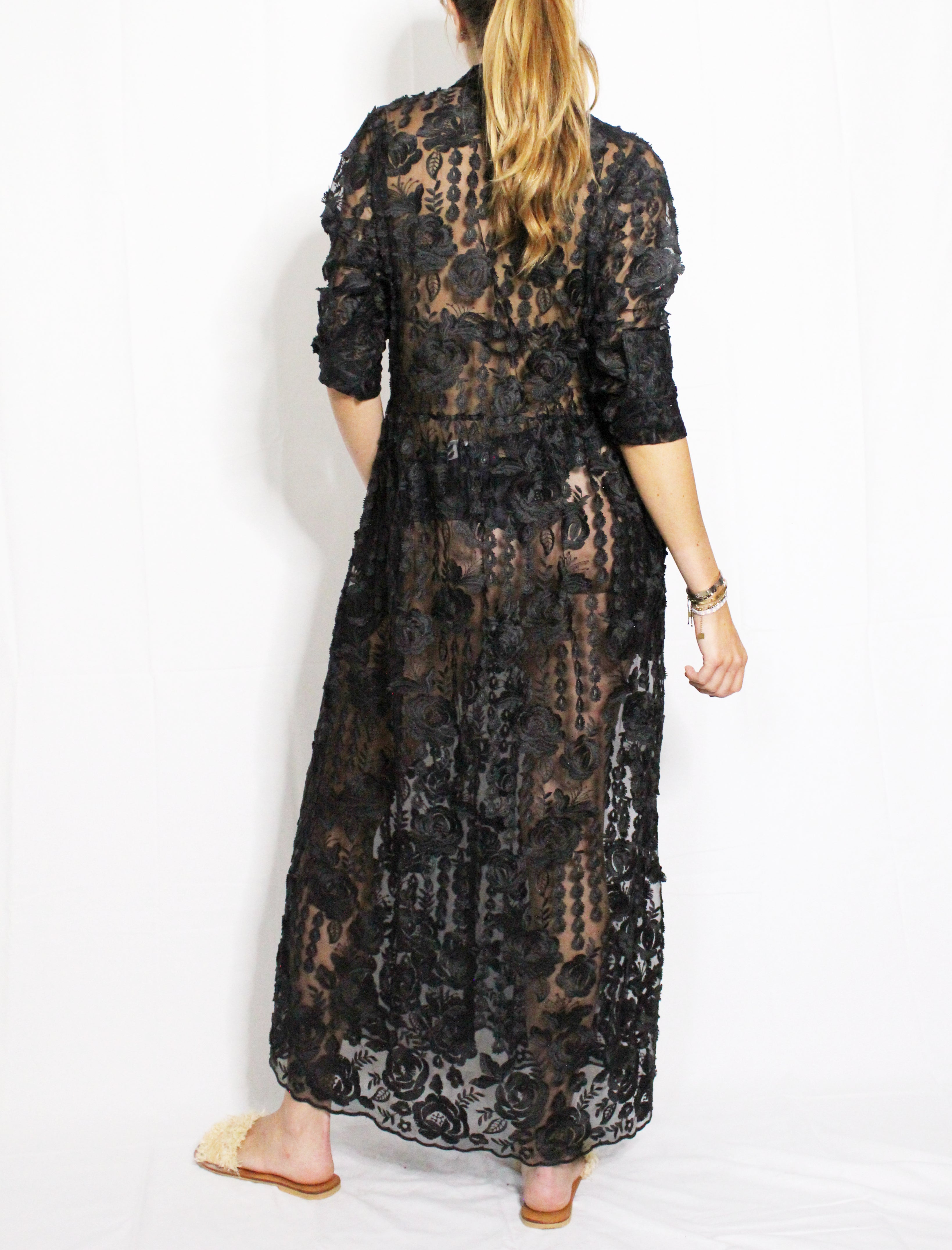 Black lace dress worn by a person on a white background. Black lace dress — handmade black lace designer dress from Hanout Boutique Marrakech, fitted, limited edition occasion piece