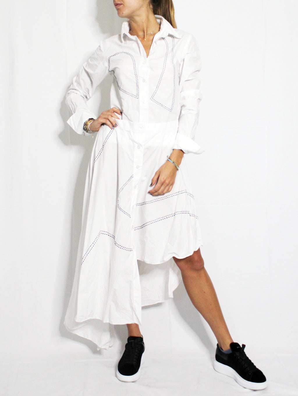 Woman wearing a white dress with black sneakers on a white background. Indonesian asymmetrical dress — handmade asymmetric designer dress from Major Minor Jakarta, relaxed fit, limited edition