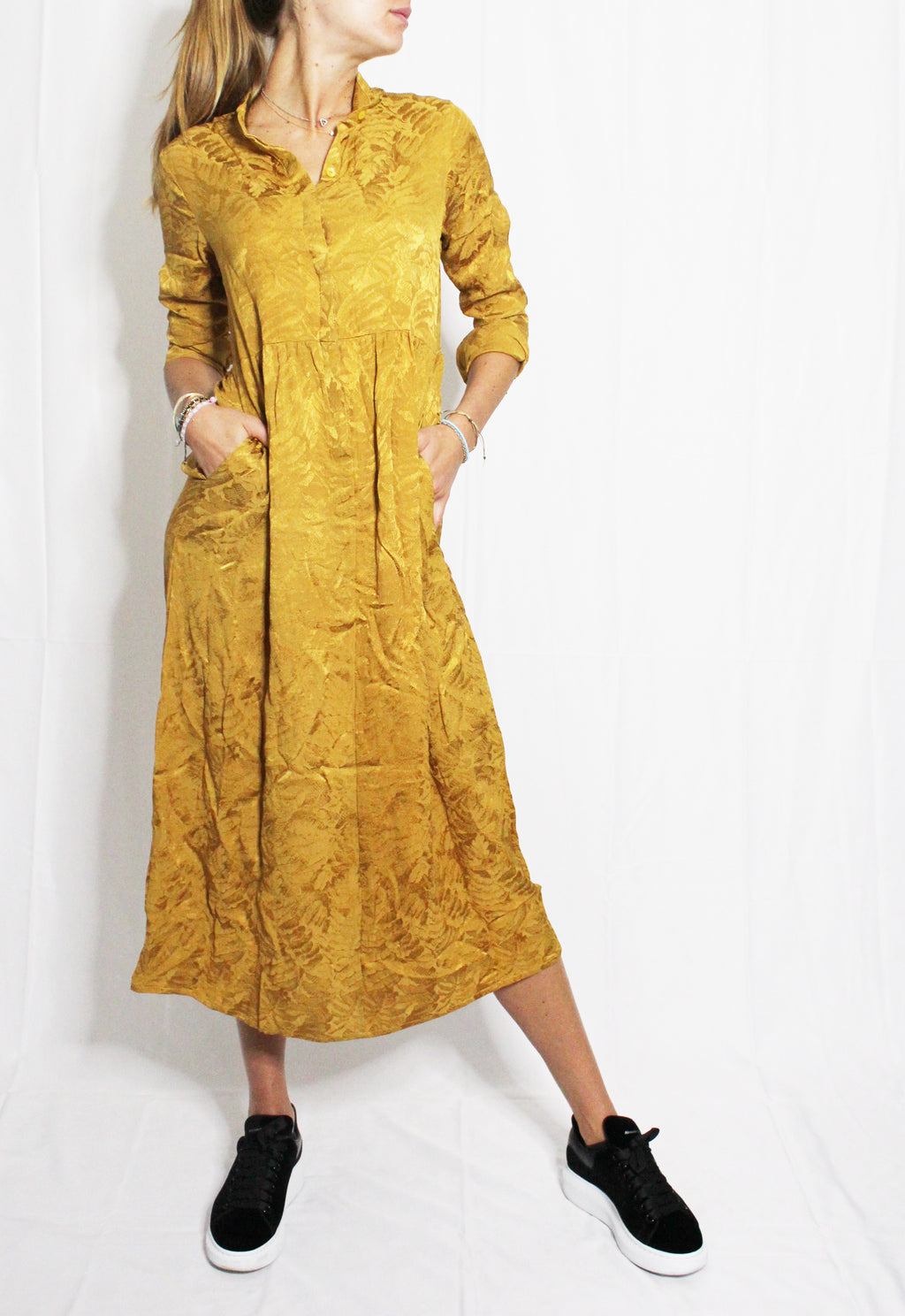 Person wearing a mustard yellow dress with long sleeves on a white background. Golden Hour dress — handmade yellow gold designer dress from Hanout Boutique Marrakech, fitted, limited edition occasion piece