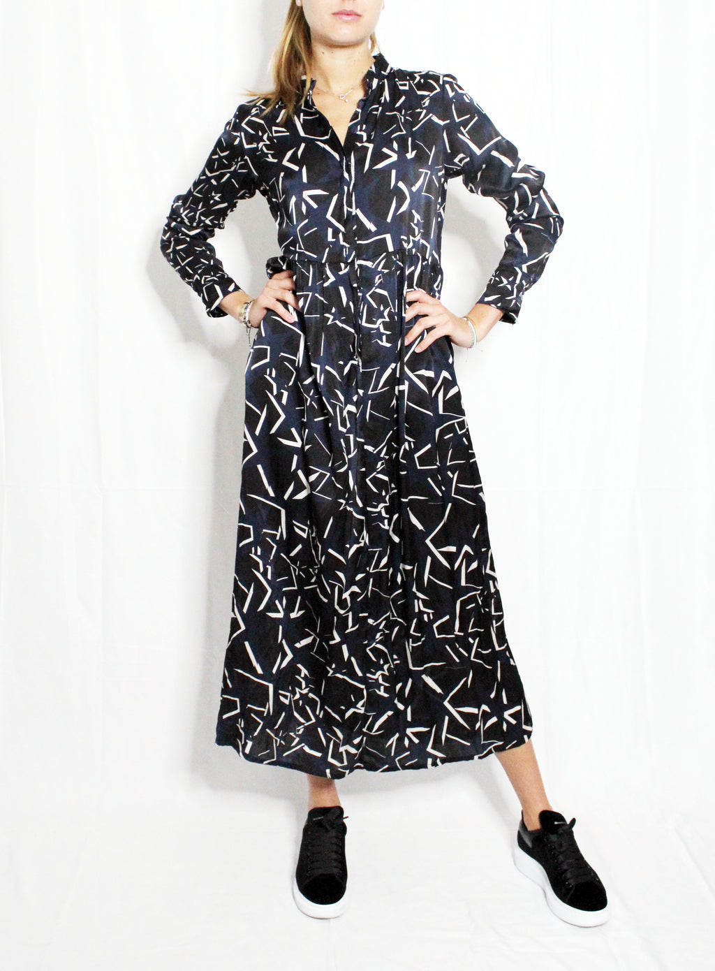 Person wearing a black and white patterned dress on a white background. Starry Night dress — handmade designer dress with starry print from Hanout Boutique Marrakech, fitted, limited edition occasion piece