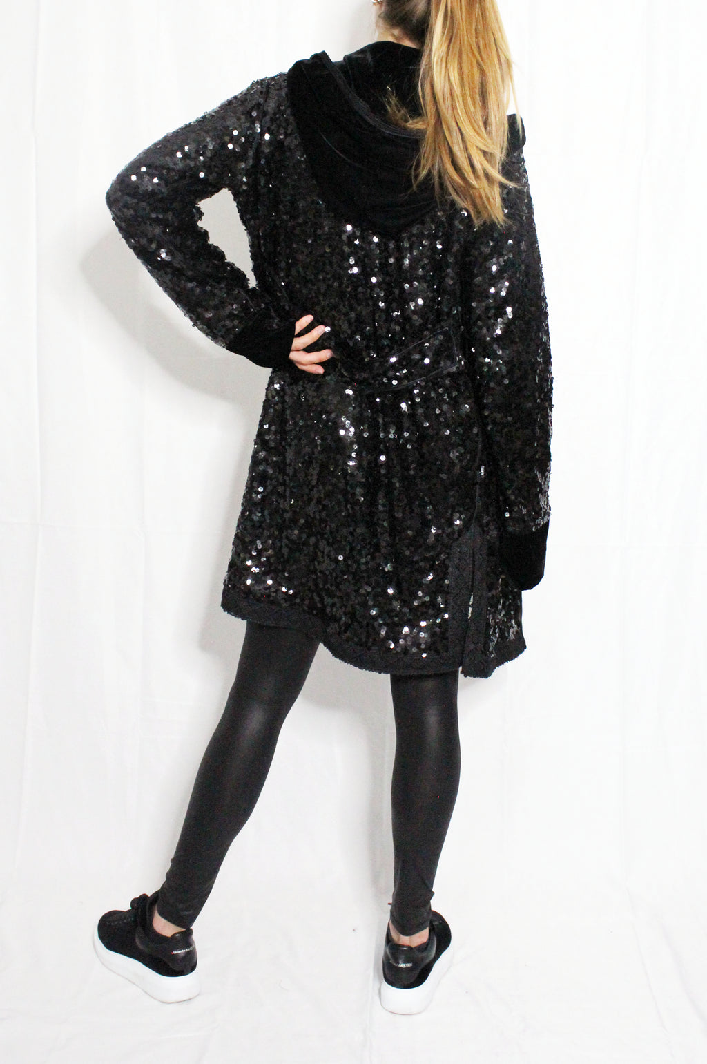 Person wearing a black sequin dress on a white background. Black sequins embroidered coat — black designer coat with hand-stitched sequin embroidery from Laure Welfling Marrakech, limited edition