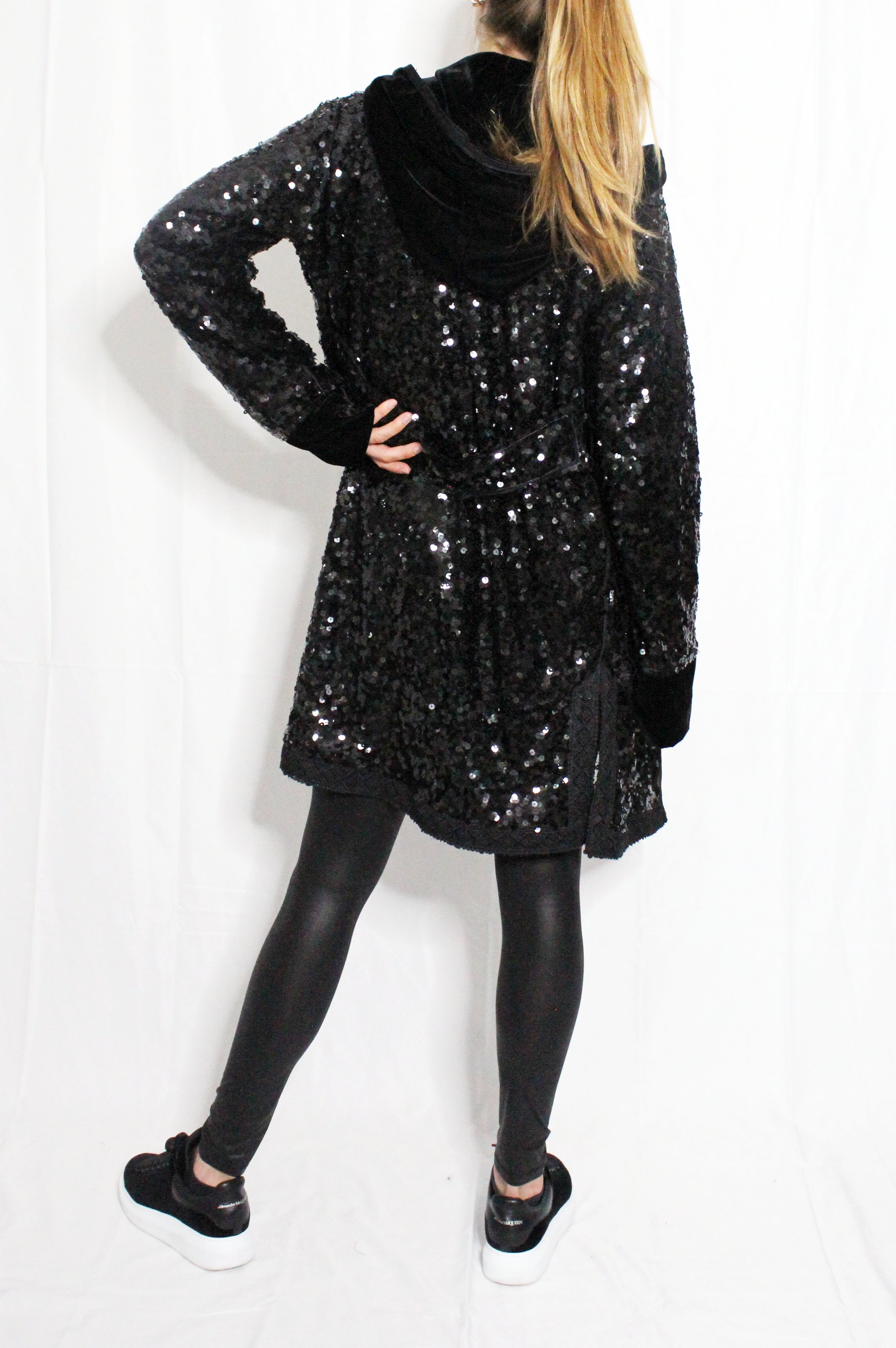 Person wearing a black sequin dress on a white background. Black sequins embroidered coat — black designer coat with hand-stitched sequin embroidery from Laure Welfling Marrakech, limited edition