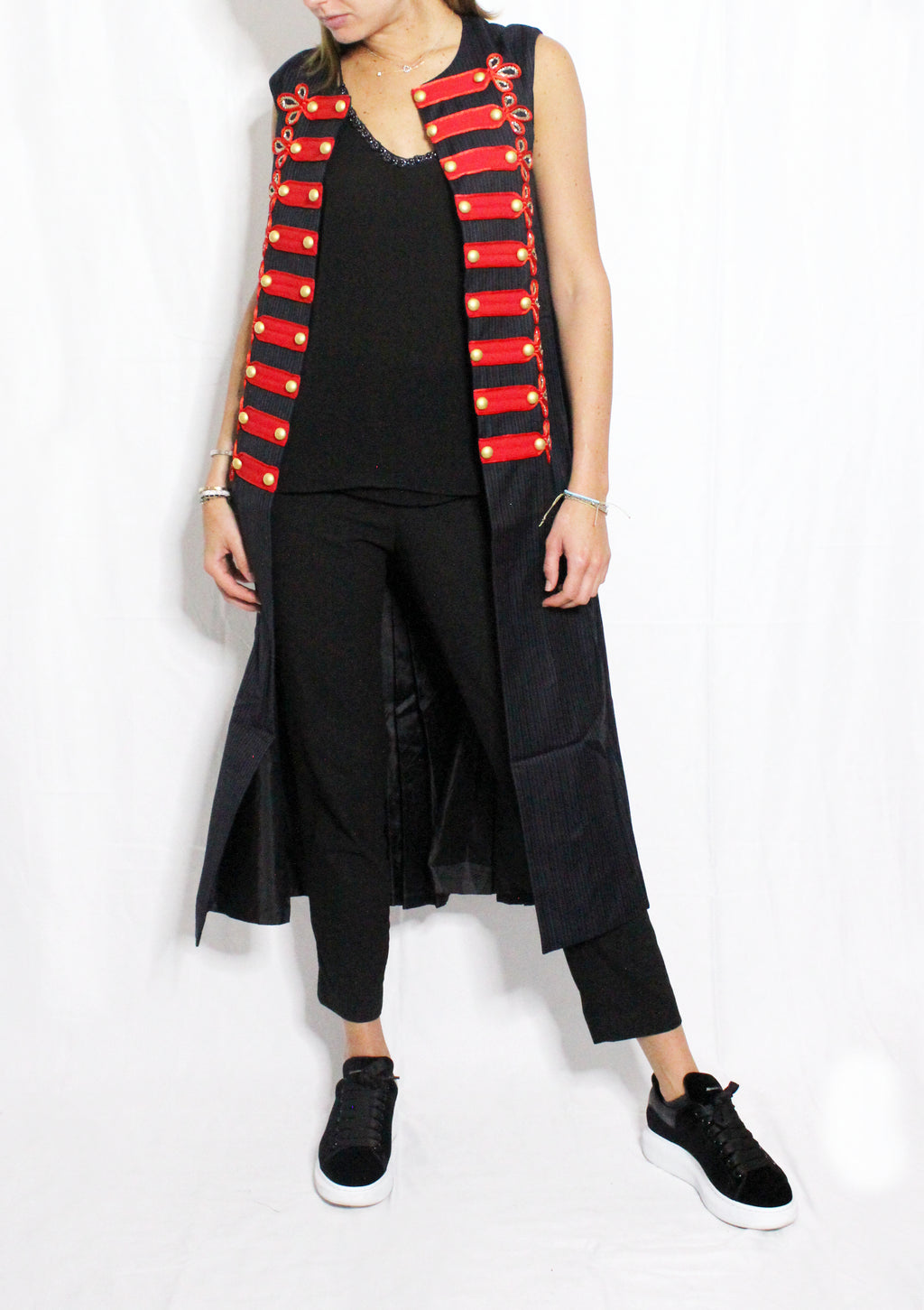 Person wearing a black outfit with a red and black striped vest on a white background. Soldier vest — handmade designer cotton vest from Major Minor Jakarta, relaxed fit, limited edition summer piece