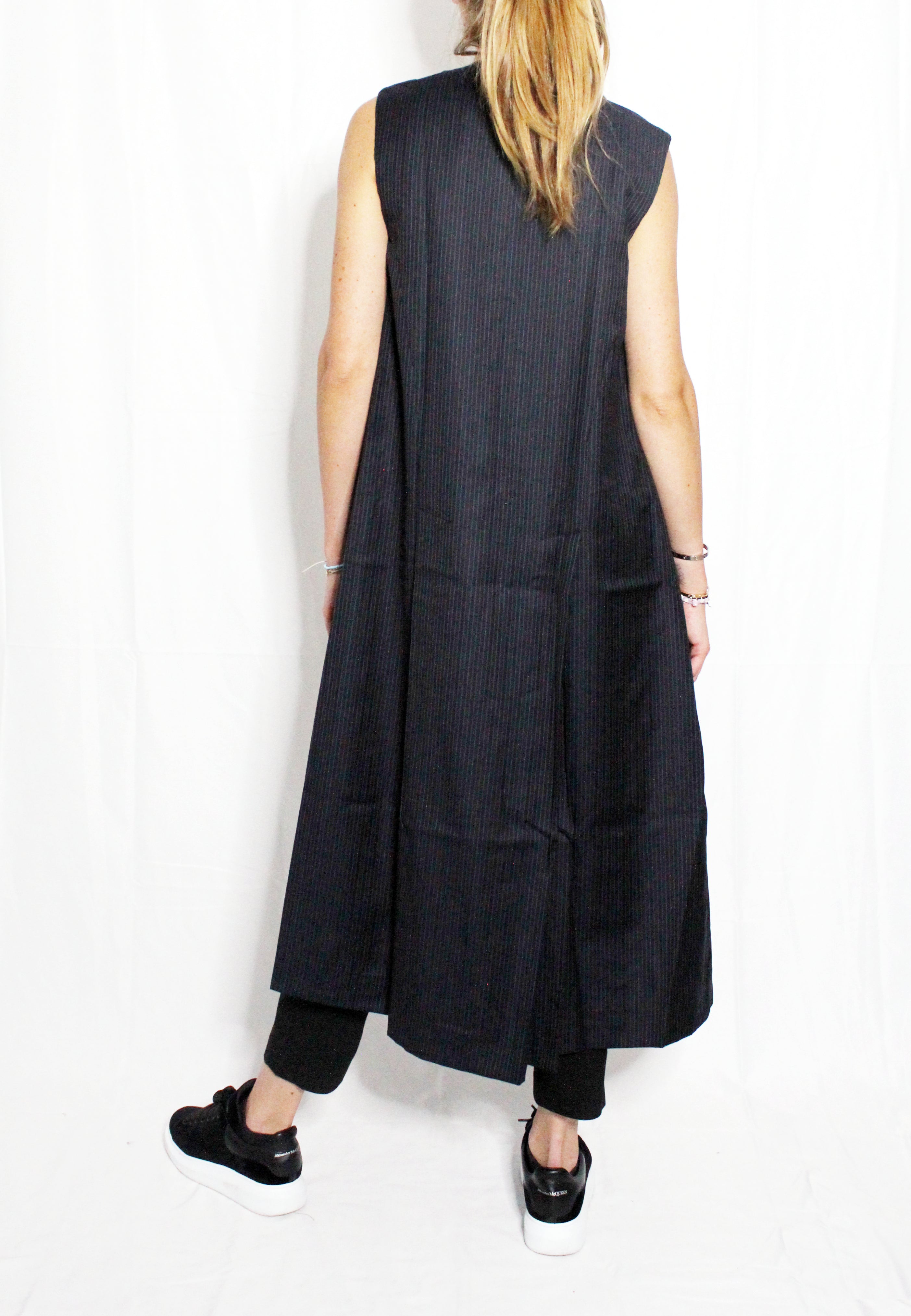 Person wearing a long black sleeveless vest against a white background. Soldier vest — handmade designer cotton vest from Major Minor Jakarta, relaxed fit, limited edition summer piece