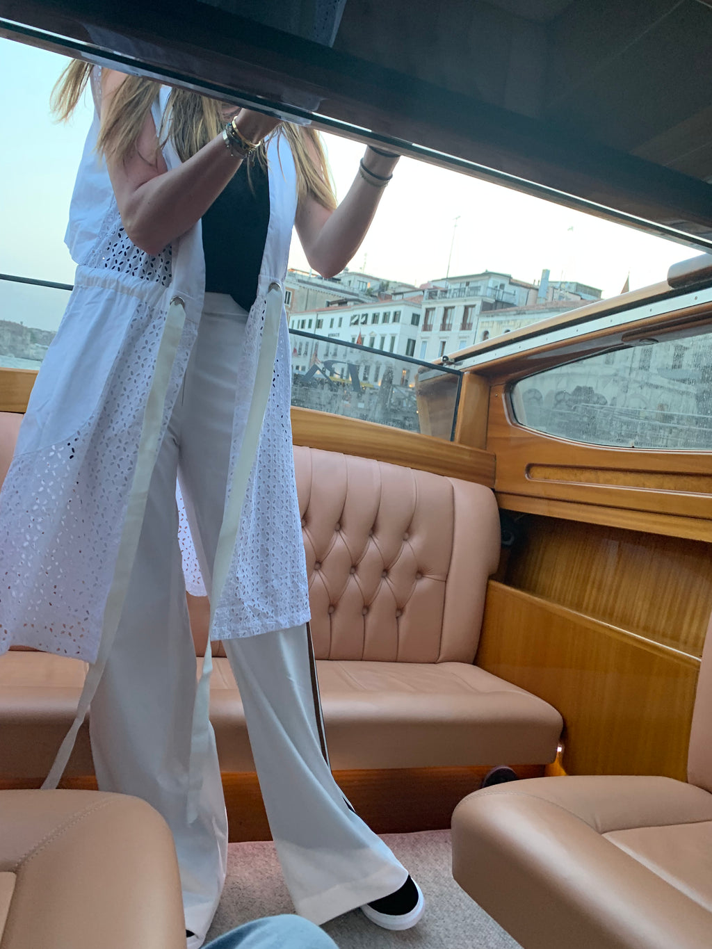 Person standing inside a boat with a scenic view outside. Indonesian cool summer vest — handmade designer cotton summer vest from Major Minor Jakarta, relaxed fit, limited edition
