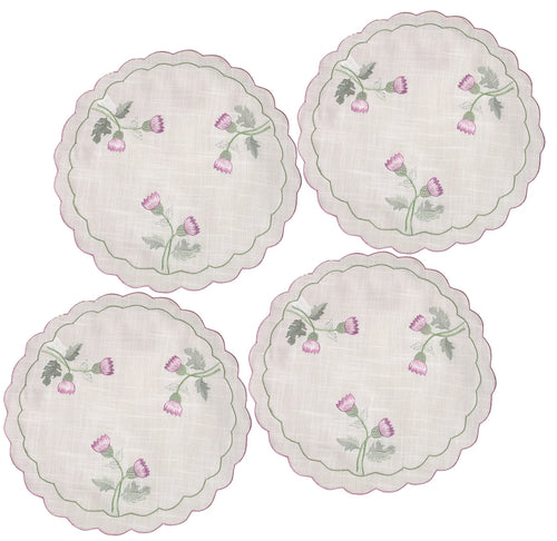 Four round embroidered placemats with floral designs on a white background. platemat