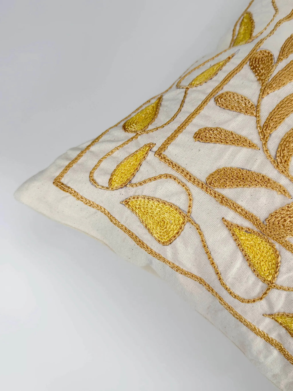 Decorative pillow with gold embroidery on a white background