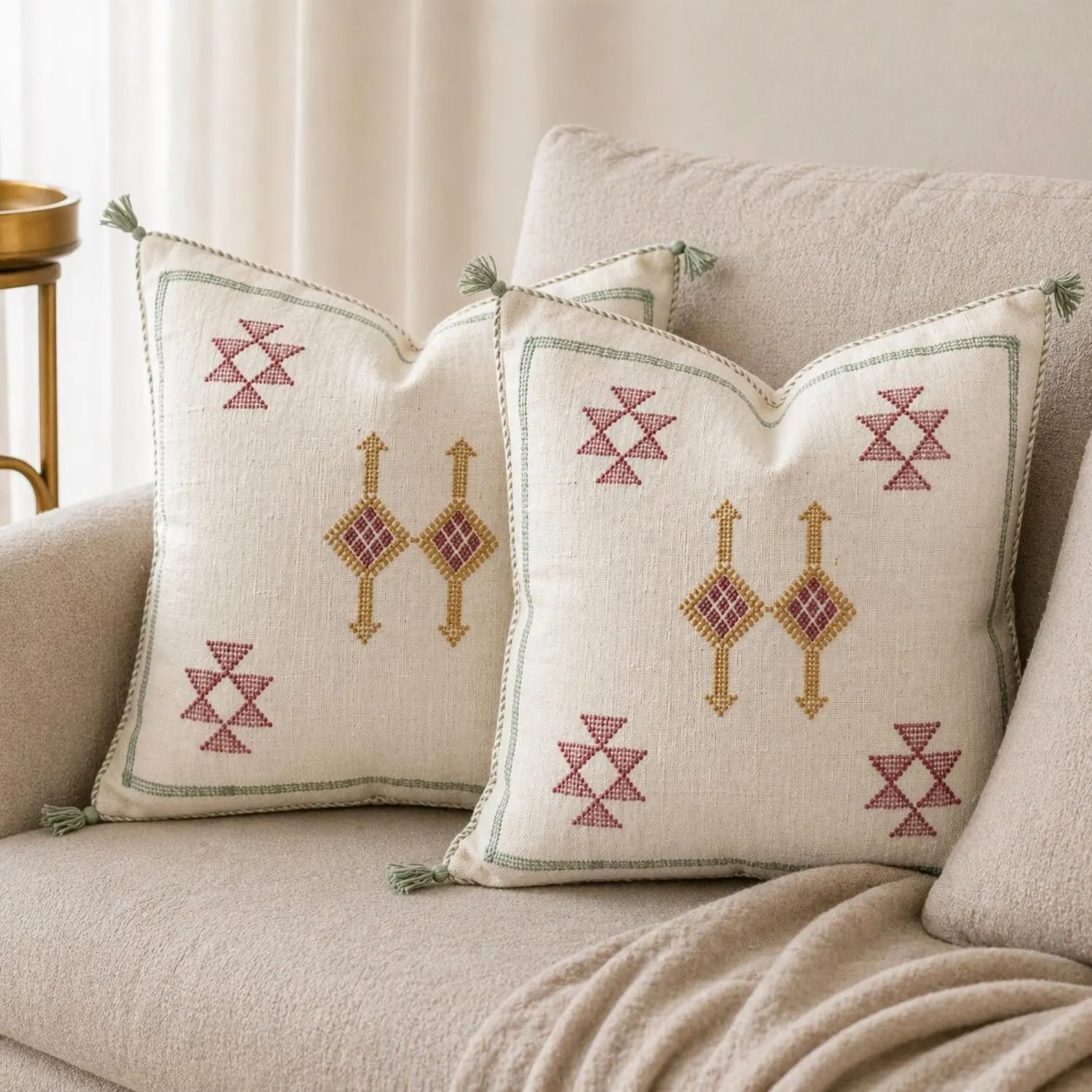 Decorative pillows with geometric patterns on a beige sofa.